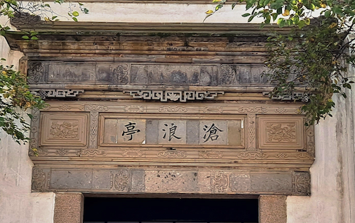 Carved Chinese lintel above a large entryway with three Chinese characters carved into it